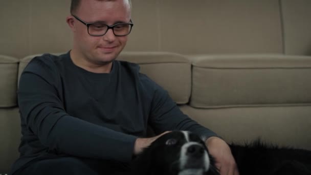 Homem Caucasiano Com Síndrome Sentado Chão Brincando Com Cão Estimação — Vídeo de Stock