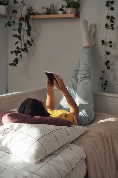 Caucasiano Adolescente Navegação Telefone Enquanto Deitado Cama Com Pernas Para — Fotografia de Stock