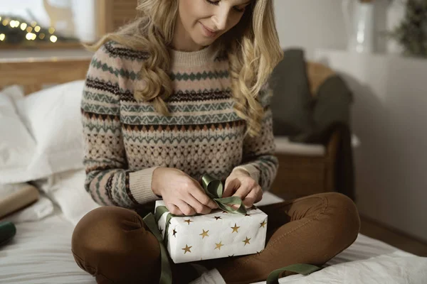 Λευκή Γυναίκα Που Κάθεται Στο Κρεβάτι Και Τυλίγει Χριστουγεννιάτικο Δώρο — Φωτογραφία Αρχείου