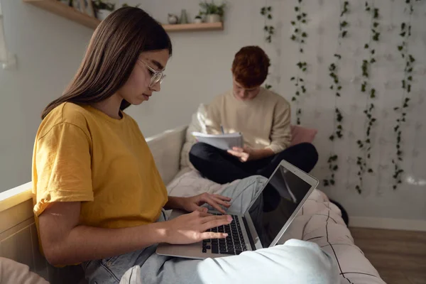 stock image Two caucasian teenagers sitting on floor and learning from books and laptop in silence