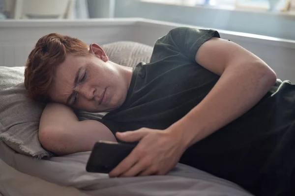 Blank Tiener Jongen Browsen Telefoon Terwijl Liggend Bed — Stockfoto