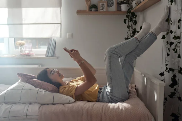 Vit Tonåring Flicka Bläddrar Telefon Medan Hon Ligger Sängen Med — Stockfoto