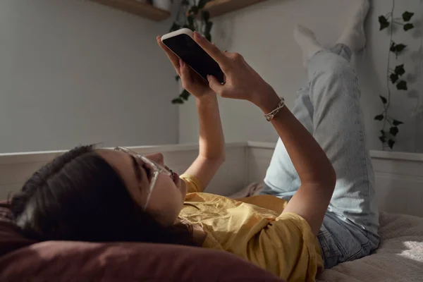 Vit Tonåring Flicka Bläddrar Telefon Medan Hon Ligger Sängen Med — Stockfoto