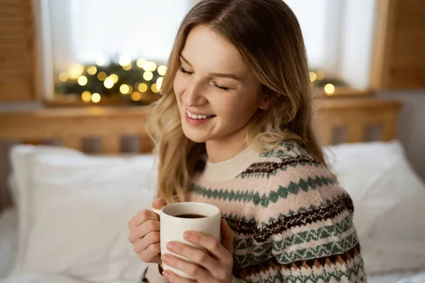 白种人年轻女人坐在床上喝咖啡 — 图库照片
