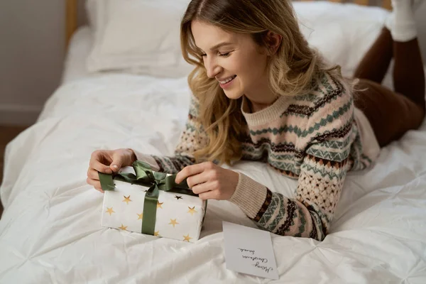 Biała Kobieta Pakująca Prezent Świąteczny Kartkę Życzeniami Leżącą Obok — Zdjęcie stockowe