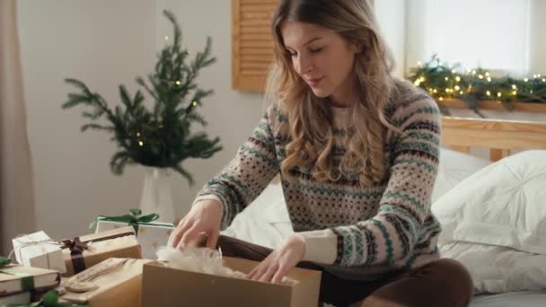 Beyaz Kadın Yatakta Oturuyor Yatak Odasında Noel Hediyesi Paketliyor Kırmızı — Stok video