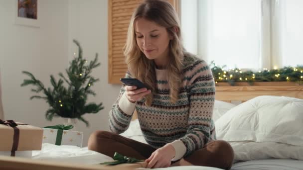Běloška Sedící Posteli Fotící Chytrým Telefonem Zabalených Vánočních Dárků Snímek — Stock video