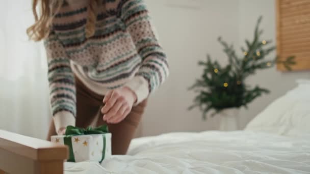 白人女性はベッドの上に横になり クリスマスプレゼントを開ける 8Kでレッドヘリウムカメラで撮影 — ストック動画