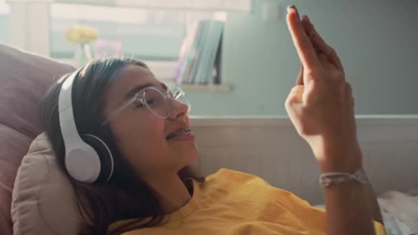 Adolescente Caucásica Que Navega Por Teléfono Con Sonrisa Usando Auriculares — Vídeos de Stock