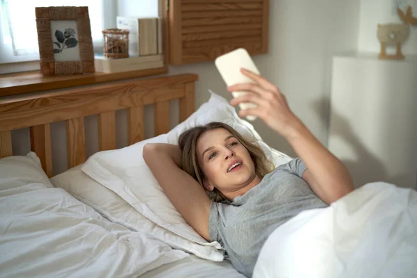 Beyaz Bir Kadın Yatakta Uzanıyor Görüntülü Konuşuyor — Stok fotoğraf