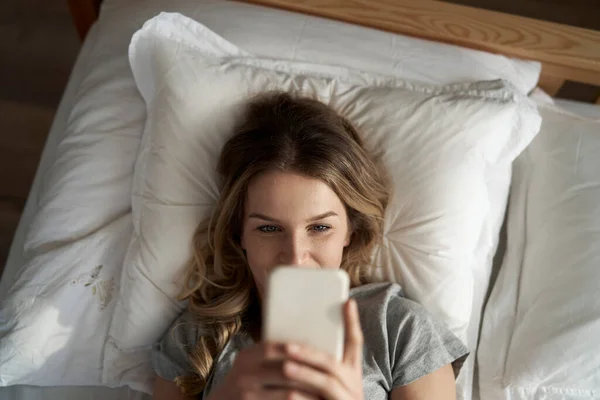 Kafkasyalı Bir Kadın Cep Telefonu Kullanıyor Yatakta Yatıyor — Stok fotoğraf