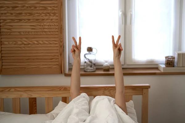 Kadın Yatakta Uzanıyor Ellerin Barış Işaretini Gösteriyor — Stok fotoğraf