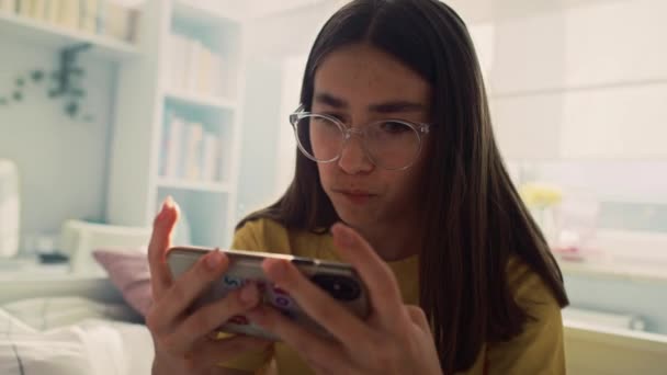 白人の十代の少女は 電話でゲームをプレイし 非常に焦点を当てます 8Kでレッドヘリウムカメラで撮影 — ストック動画