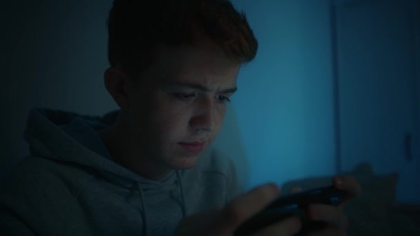 Geceleri Odasında Otururken Cep Telefonu Kullanan Ciddi Bir Beyaz Çocuk — Stok video
