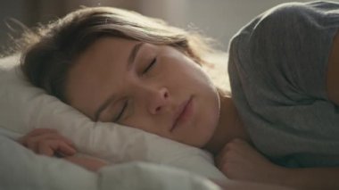 Kafkasyalı bir kadının yatakta uyuduğu yakın plan. 8K 'da kırmızı helyum kamerayla çekildi.. 