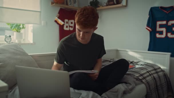 Blanke Tienerjongen Die Bed Zit Aantekeningen Maakt Vanaf Een Laptop — Stockvideo