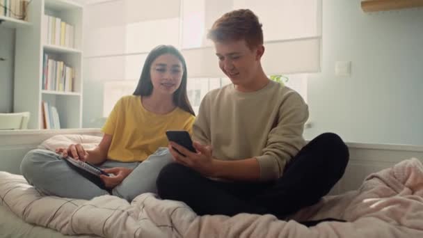 Två Kaukasiska Tonårsvänner Har Roligt När Använder Mobiltelefoner Sovrummet Skjuten — Stockvideo