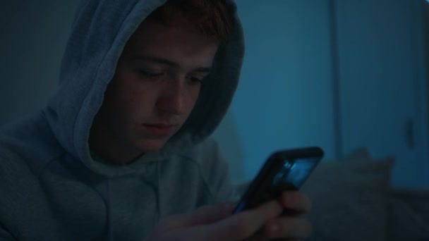 Fokusera Kaukasiska Tonårspojken Använder Mobiltelefon Medan Sitter Natten Sitt Rum — Stockvideo