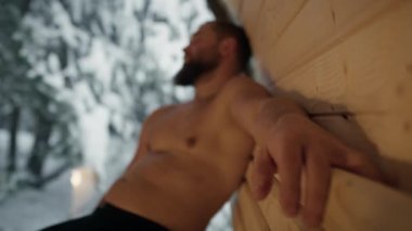 Caucasian man enjoying in the sauna in winter. Shot with RED helium camera in 8K.      