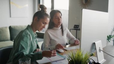 Focus two women working and analyzing something on computer at home. Shot with RED helium camera in 8K.  