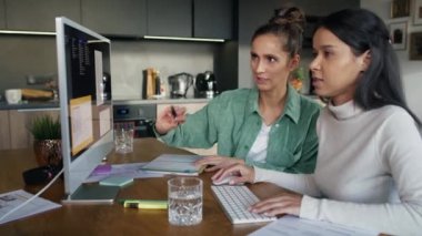 Two women working and analyzing something on computer at home. Shot with RED helium camera in 8K.   