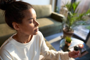 Evde meditasyon yapan melez kadınlara yakın durun.