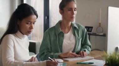 Two women working and analyzing something on computer at home. Shot with RED helium camera in 8K.  