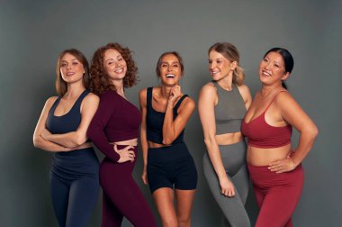 Group of five young women in sports clothes in studio shot