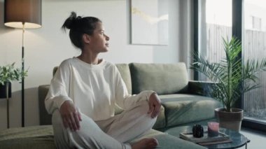 Natural woman meditating at home and looking in sun side. Shot with RED helium camera in 8K.