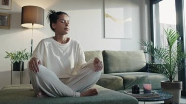 Natural woman meditating at home with eyes closed. Shot with RED helium camera in 8K. 