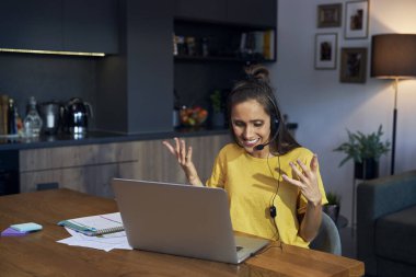 Excited caucasian woman working as call center at home