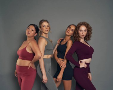 Four young women in sports clothes in studio shot
