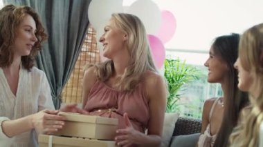 Group of caucasian women giving gifts to friend in pregnant. Shot with RED helium camera in 8K. 