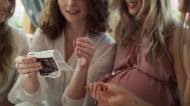 Group of female friends looking an ultrasound scan result. Shot with RED helium camera in 8K. 