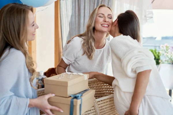 Group of caucasian women giving gifts to friend in pregnant