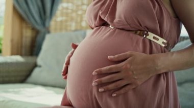 Low section of pregnant woman wearing elegance dress. Shot with RED helium camera in 8K.    