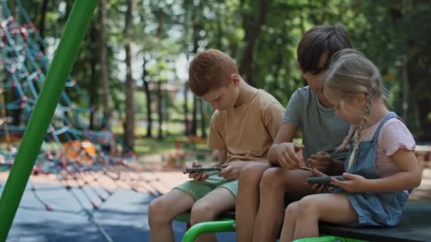 Ομαδικοί Φίλοι Που Χρησιμοποιούν Κινητό Τηλέφωνο Στην Παιδική Χαρά Καλοκαίρι — Αρχείο Βίντεο