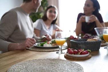 Close up of lunch on the table and caucasian family in background