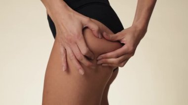 Unrecognizable woman touching and pressing skin on her hip. Shot with RED helium camera in 8K.