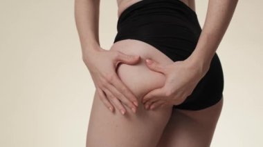 Unrecognizable woman touching and pressing skin on her hip. Shot with RED helium camera in 8K. 