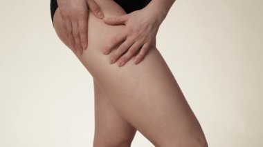 Unrecognizable woman touching and pressing skin on her hip. Shot with RED helium camera in 8K. 