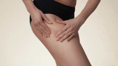 Unrecognizable woman touching and pressing skin on her hip. Shot with RED helium camera in 8K. 