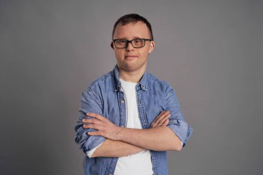 Portrait of man with down syndrome on gray background