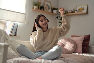 Kafkasyalı genç kız kulaklık takıyor ve telefonundan müzik dinliyor. 