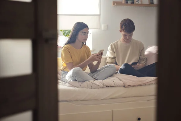 Dua Teman Remaja Kaukasia Duduk Tempat Tidur Dan Browsing Telepon — Stok Foto