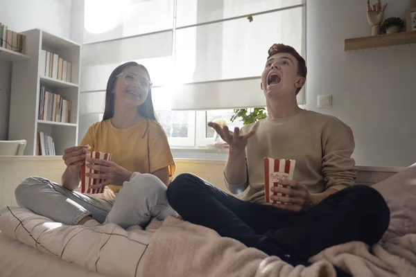 Dwóch Białych Nastolatków Zabawia Się Siedząc Podłodze Jedząc Popcorn — Zdjęcie stockowe