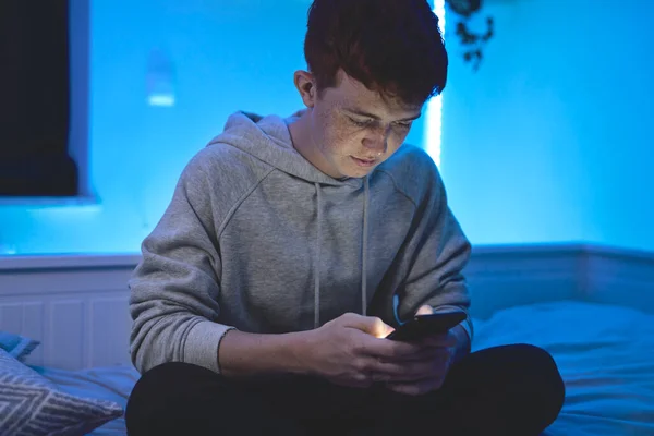 Fókuszban Kaukázusi Tinédzser Fiú Használja Mobiltelefon Miközben Éjjel Szobájában — Stock Fotó