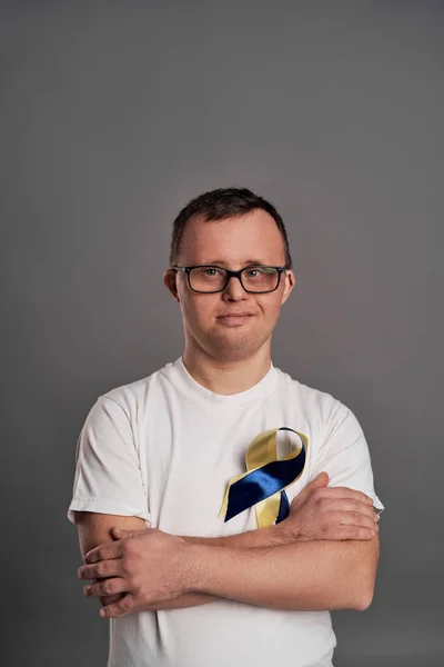 Portrét Muže Downovým Syndromem Šedém Pozadí Žlutou Modrou Mašlí — Stock fotografie