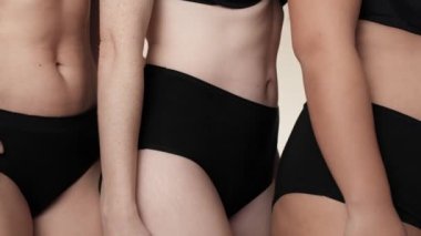 Yan yana duran siyah iç çamaşırlı, tanınmayan kadınların olduğu bir yere. 8K 'da kırmızı helyum kamerayla çekildi..  