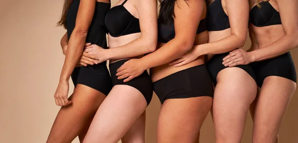 四个穿着黑色内裤 无法辨认的女人排成一排 手挽着臀部的侧视图 — 图库照片